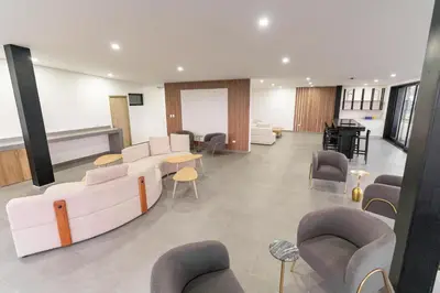 a waiting room with couches and tables and chairs at Luxury apartment at Galerias in San Salvador