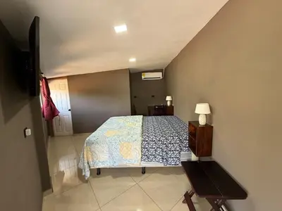 a small bedroom with a bed and a table at Mini Room El Mangal B&B in Suchitoto