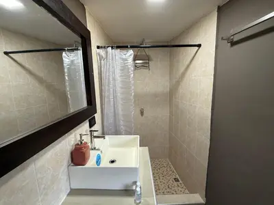 a bathroom with a white sink and a shower at Mini Room El Mangal B&B in Suchitoto