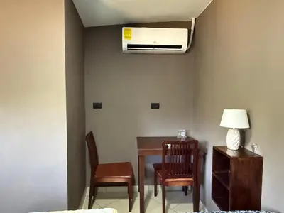 a room with a table and chairs and a air conditioner at Mini Room El Mangal B&B in Suchitoto