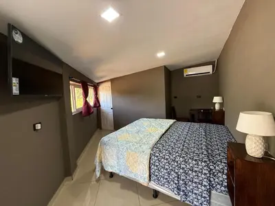 a bedroom with a bed and a lamp and a window at Mini Room El Mangal B&B in Suchitoto