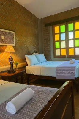 a bedroom with two beds and a window at Los Cuatro Olivos Hotel Boutique in Juayúa