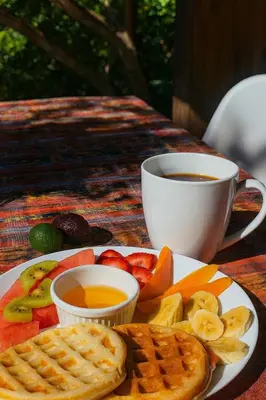 a plate of breakfast food with a cup of coffee at Los Cuatro Olivos Hotel Boutique in Juayúa