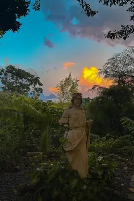 a statue of a woman in a field at sunset at Los Cuatro Olivos Hotel Boutique in Juayúa