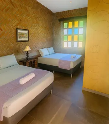 a bedroom with two beds and a window at Los Cuatro Olivos Hotel Boutique in Juayúa