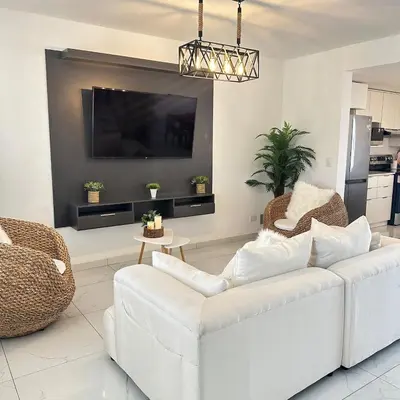 a living room with a white couch and a tv at Beauty delux home in San Miguel