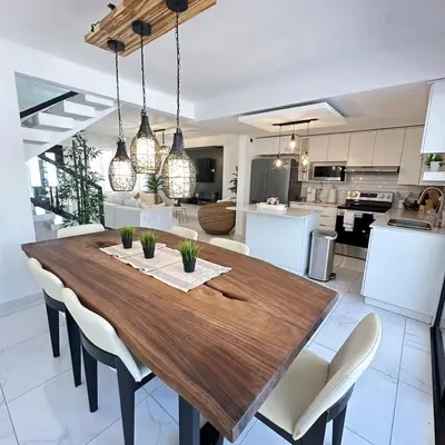 a kitchen and dining room with a wooden table and chairs at Beauty delux home in San Miguel