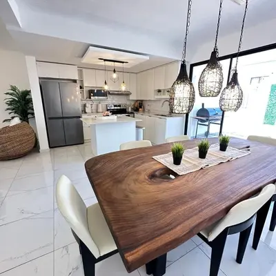 a kitchen and dining room with a wooden table and chairs at Beauty delux home in San Miguel