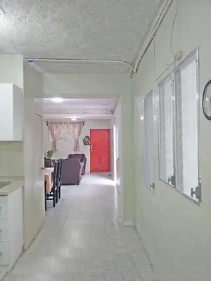 a hallway of a living room with a red door at Queen Bed in San Salvador