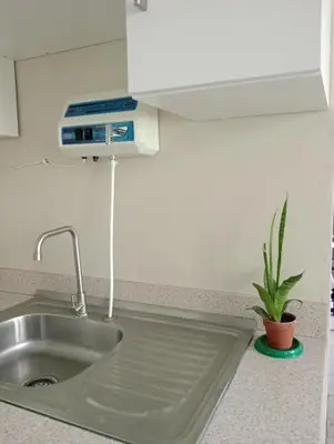 a kitchen sink with a air freshener above it at Queen Bed in San Salvador