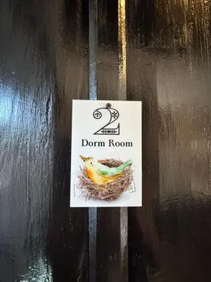 a sign on a door with a bird in a nest at Urban Nest Hostel in Santa Ana