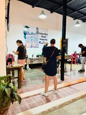 a woman in a black dress standing in a room at Urban Nest Hostel in Santa Ana