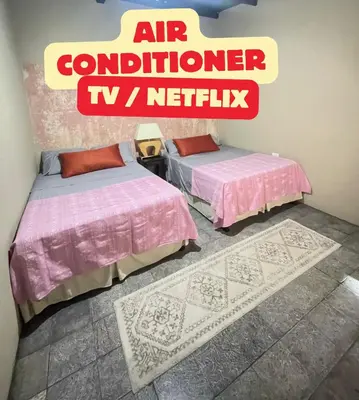 two beds in a room with a sign that reads air controller tv network at Urban Nest Hostel in Santa Ana