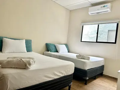 a room with two beds and a window at Conchita's, near Mall metrocentro, AC, SHW in Santa Ana