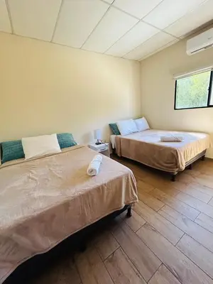 a room with two beds and a window at Conchita's, near Mall metrocentro, AC, SHW in Santa Ana