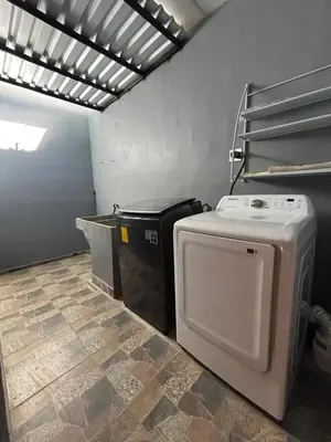 a laundry room with a washer and dryer in it at Conchita's, near Mall metrocentro, AC, SHW in Santa Ana