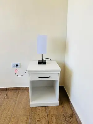 a white table with a lamp and an outlet at Conchita's, near Mall metrocentro, AC, SHW in Santa Ana