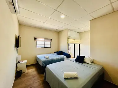 a room with two beds and a tv in it at Conchita's, near Mall metrocentro, AC, SHW in Santa Ana