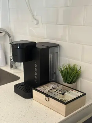 a black coffee maker on a counter with a book at Elegant Modern Tiny Home in San Miguel