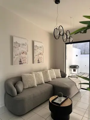 a living room with a gray couch and a table at Elegant Modern Tiny Home in San Miguel