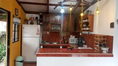 a kitchen with wooden cabinets and a white refrigerator at Cabaña Mi Bello Jardín, Privado, Zona Urbana in Apaneca