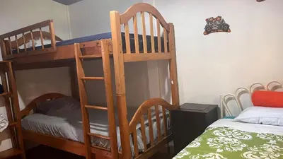 two bunk beds in a room with a bed at Cabaña Mi Bello Jardín, Privado, Zona Urbana in Apaneca