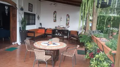 a living room with a table and chairs at Cabaña Mi Bello Jardín, Privado, Zona Urbana in Apaneca