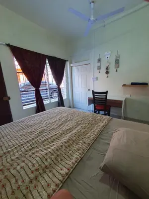a bedroom with a large bed with a table and a desk at Zacatecoluca House in Zacatecoluca