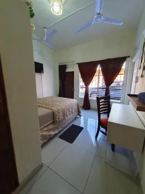 a bedroom with a bed and a desk and window at Zacatecoluca House in Zacatecoluca