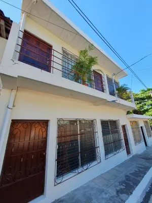 a house with a balcony and two doors at Zacatecoluca House in Zacatecoluca