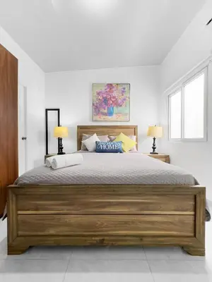 a bedroom with a large wooden bed with two lamps at Modern Retreat in San Miguel