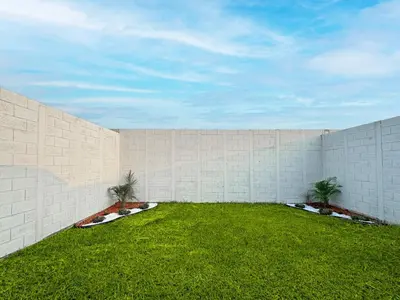 a brick wall with two palm trees in a yard at Modern Retreat in San Miguel