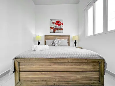 a bedroom with a large wooden bed with two lamps at Modern Retreat in San Miguel