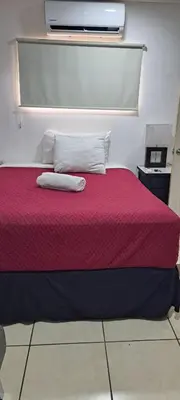 a bedroom with a red bed with two pillows at May Apartamento in San Salvador
