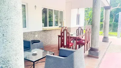 a patio with a table and chairs on a porch at Golden Sunset House in Acajutla