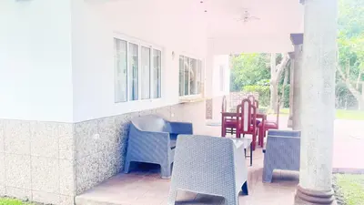 a group of chairs and tables on a porch at Golden Sunset House in Acajutla