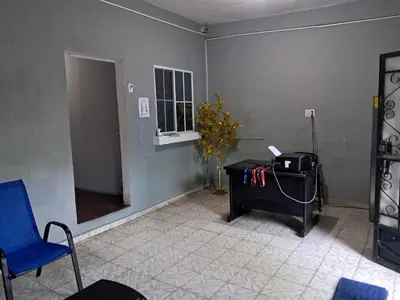 a room with a desk and a blue chair and a window at Hostal Venezuela in San Salvador