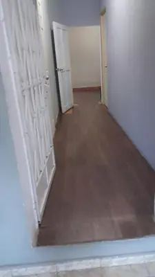 a hallway with two white doors and a wooden floor at Hostal Venezuela in San Salvador
