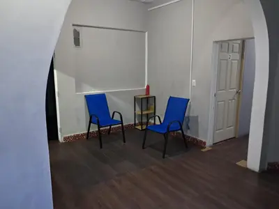 two blue chairs and a table in a room at Hostal Venezuela in San Salvador