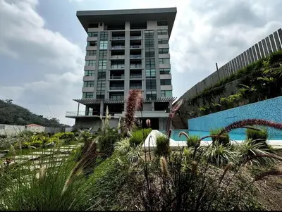 a hotel with a swimming pool in front of a building at Park Tower 804 in Nuevo Cuscatlán