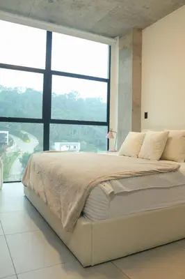 a bedroom with a large bed with a large window at Park Tower 804 in Nuevo Cuscatlán