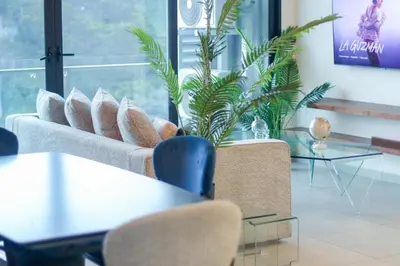 a living room with a couch and tables and a plant at Park Tower 804 in Nuevo Cuscatlán