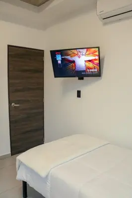 a room with a bed and a flat screen tv on the wall at Park Tower 804 in Nuevo Cuscatlán
