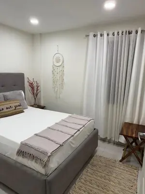 a bedroom with a large bed and a clock on the wall at La Bella Suite in San Salvador