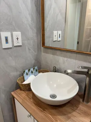 a bathroom with a white sink and a mirror at La Bella Suite in San Salvador