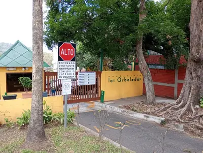 a stop sign in front of a building with trees at La Bella Suite in San Salvador