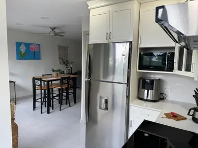 a kitchen with a stainless steel refrigerator and a table at La Bella Suite in San Salvador