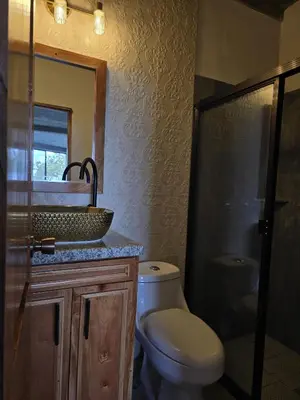 a bathroom with a toilet and a sink and a mirror at Hotel Vista Hermosa Suchitoto in Suchitoto