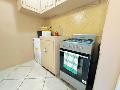 a kitchen with a stove and a refrigerator at Apartamento completo Ideal para descansar en familia en San Salvador in San Salvador