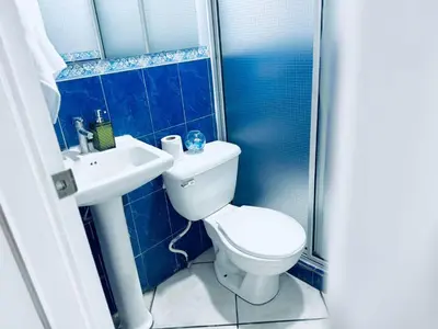 a blue tiled bathroom with a toilet and a sink at Apartamento completo Ideal para descansar en familia en San Salvador in San Salvador